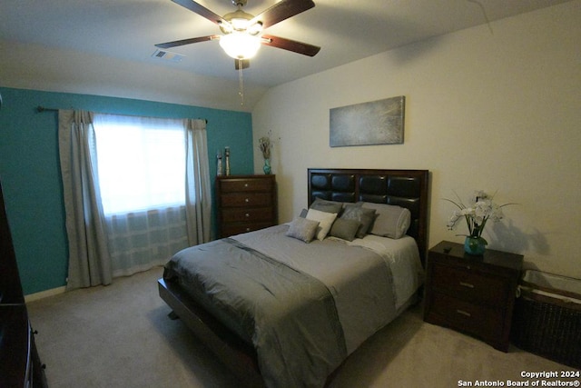 bedroom featuring ceiling fan, light carpet, and vaulted ceiling