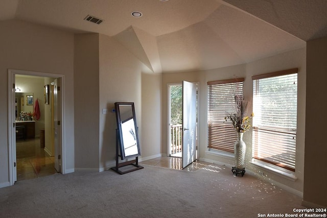 interior space featuring light colored carpet and lofted ceiling