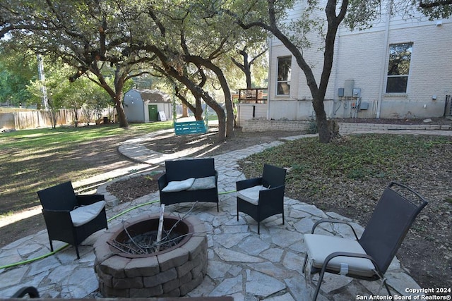 view of patio featuring a fire pit and a storage shed