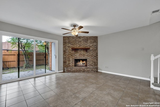 unfurnished living room with tile patterned floors, a brick fireplace, and ceiling fan