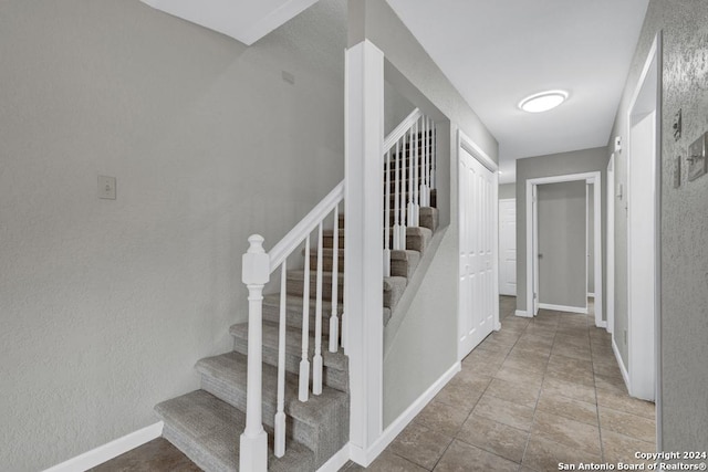 stairway with tile patterned floors