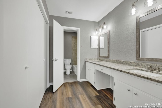 bathroom with hardwood / wood-style floors, vanity, and toilet