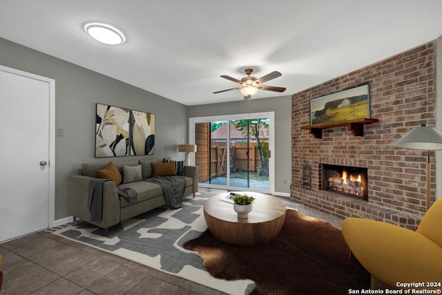 tiled living room featuring a brick fireplace and ceiling fan