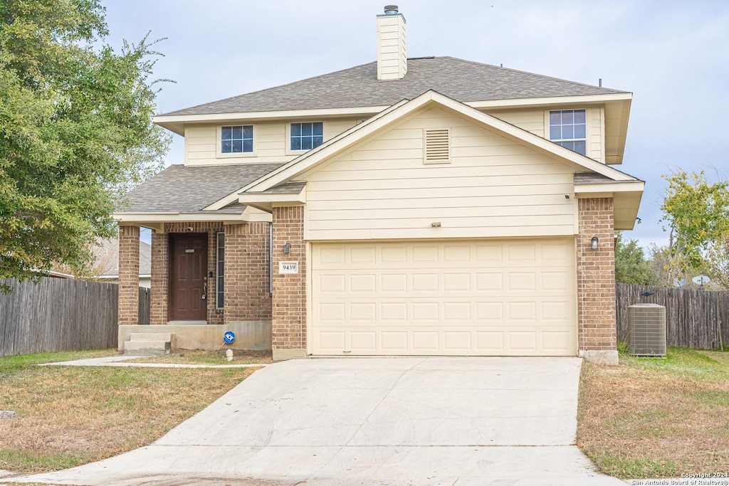 view of front of property with a garage and central AC unit