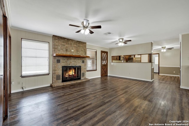 unfurnished living room featuring dark hardwood / wood-style floors, a brick fireplace, ceiling fan, and ornamental molding