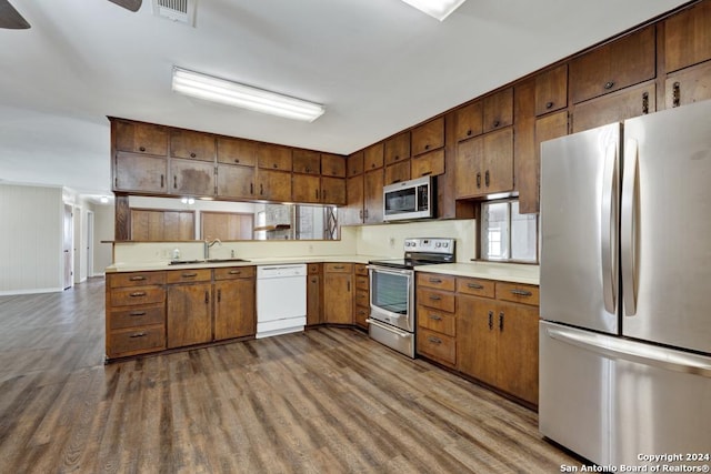 kitchen with appliances with stainless steel finishes, sink, and wood-type flooring