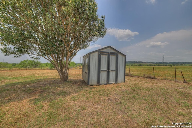 view of outdoor structure featuring a rural view and a yard