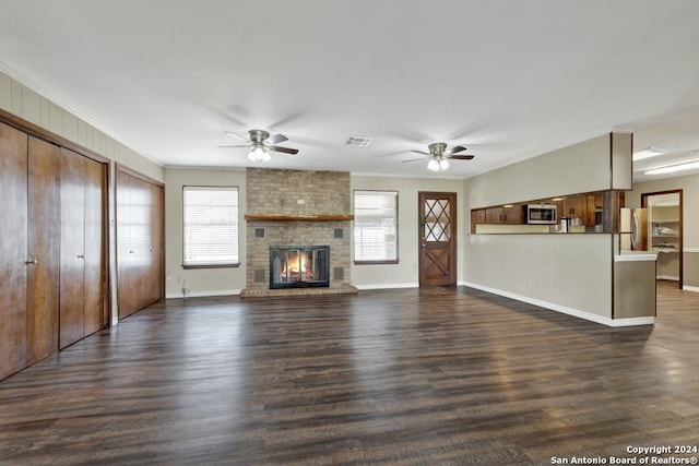 unfurnished living room with a fireplace, dark hardwood / wood-style flooring, ceiling fan, and ornamental molding