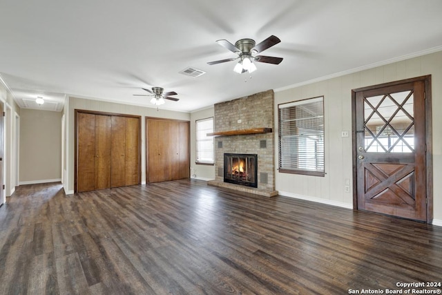 unfurnished living room featuring a fireplace, ornamental molding, ceiling fan, and dark wood-type flooring