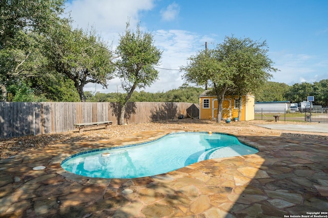 view of pool featuring a patio area and a storage unit