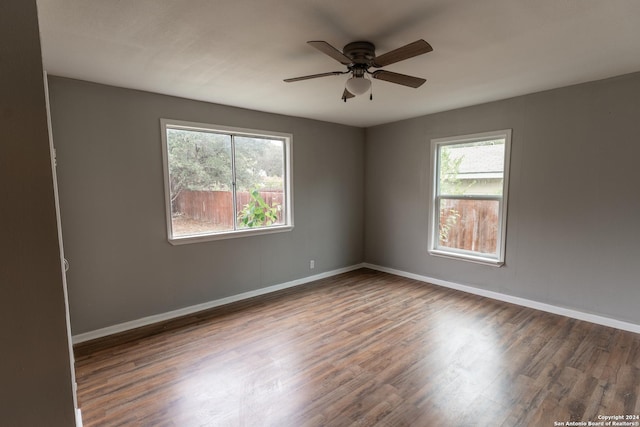 spare room with dark hardwood / wood-style flooring and ceiling fan