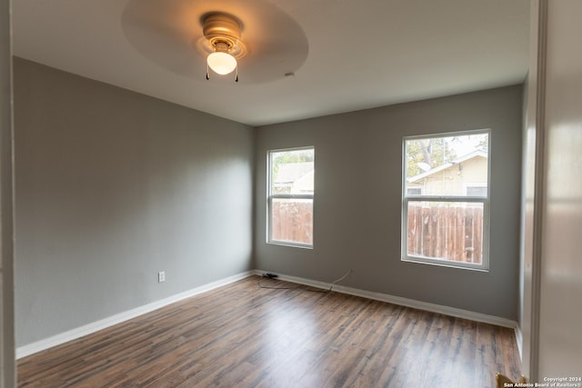 unfurnished room with dark hardwood / wood-style flooring and ceiling fan