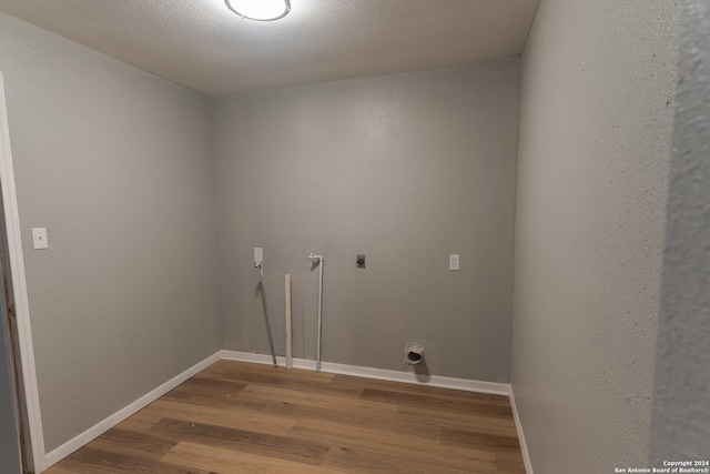 clothes washing area with wood-type flooring, a textured ceiling, and electric dryer hookup