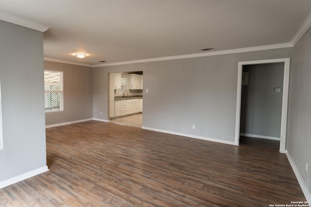 unfurnished room with hardwood / wood-style floors, ornamental molding, and sink