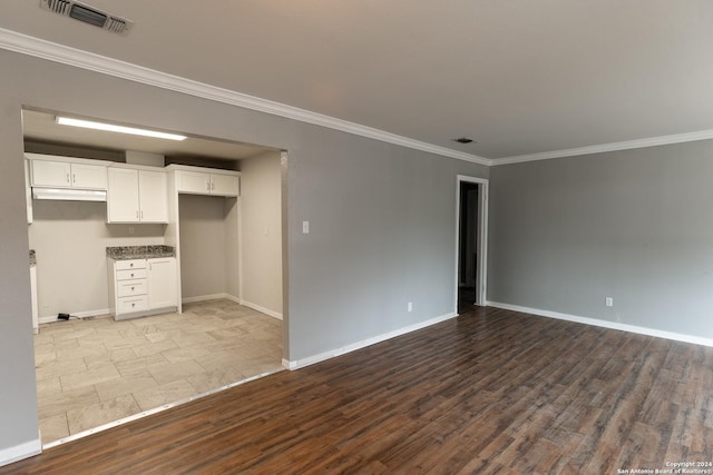 empty room with light hardwood / wood-style floors and crown molding