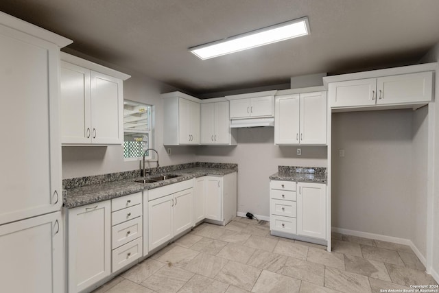 kitchen featuring white cabinetry and sink