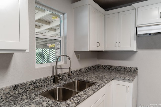 kitchen with sink, white cabinets, and dark stone counters