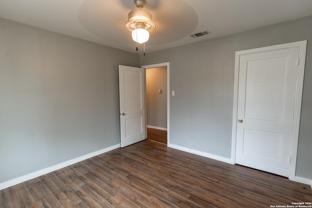 unfurnished bedroom featuring ceiling fan and dark wood-type flooring