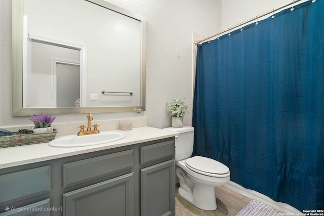 bathroom with a shower with curtain, toilet, vanity, and hardwood / wood-style flooring