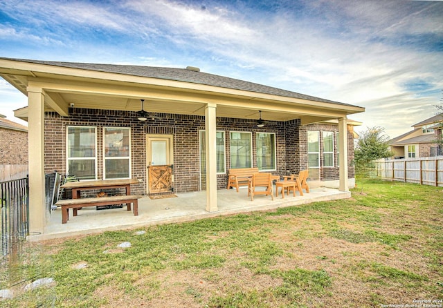 back of property with a patio area, ceiling fan, and a yard