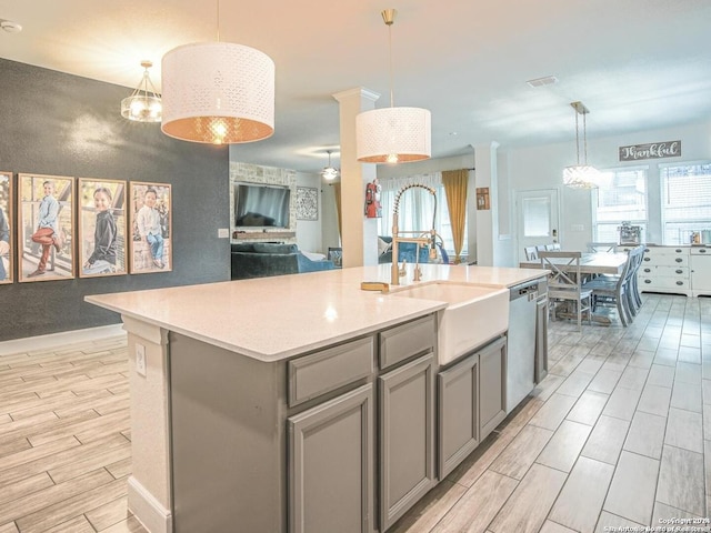 kitchen with dishwasher, pendant lighting, a center island with sink, and plenty of natural light