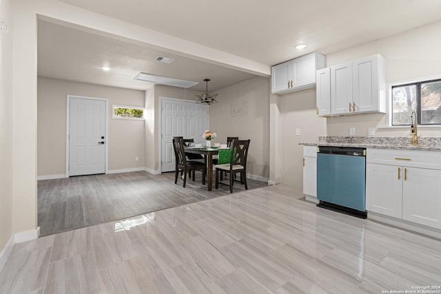 kitchen with light wood-type flooring, white cabinets, light stone counters, sink, and dishwasher