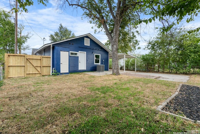 back of property with cooling unit and a yard