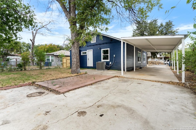 view of front of home with a carport and central air condition unit