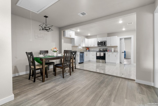 dining area with light wood-type flooring and sink