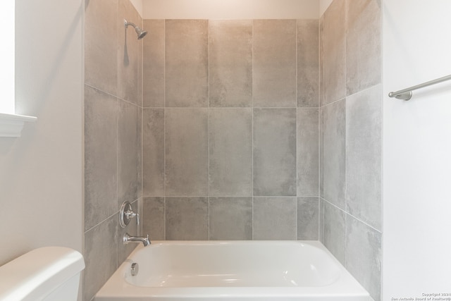 bathroom with tiled shower / bath and toilet