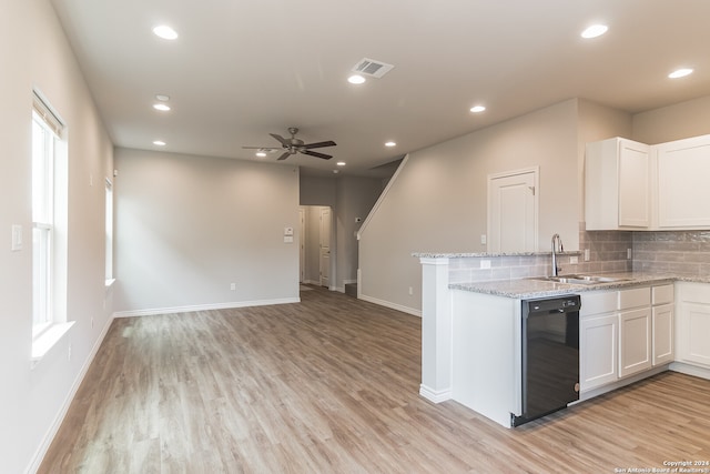 kitchen featuring white cabinetry, sink, light stone countertops, black dishwasher, and light wood-type flooring