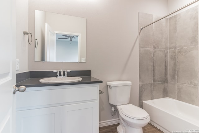 full bathroom with tiled shower / bath, ceiling fan, vanity, and toilet