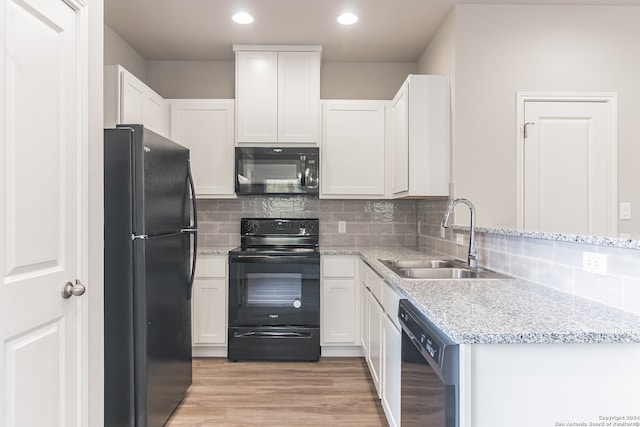 kitchen featuring backsplash, black appliances, sink, light wood-type flooring, and white cabinetry