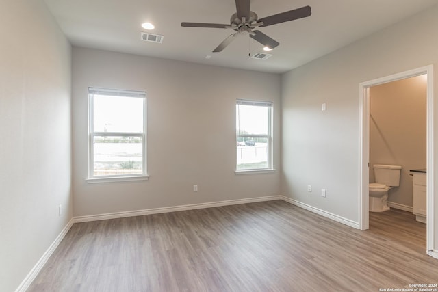 unfurnished bedroom featuring light wood-type flooring, ensuite bath, and ceiling fan