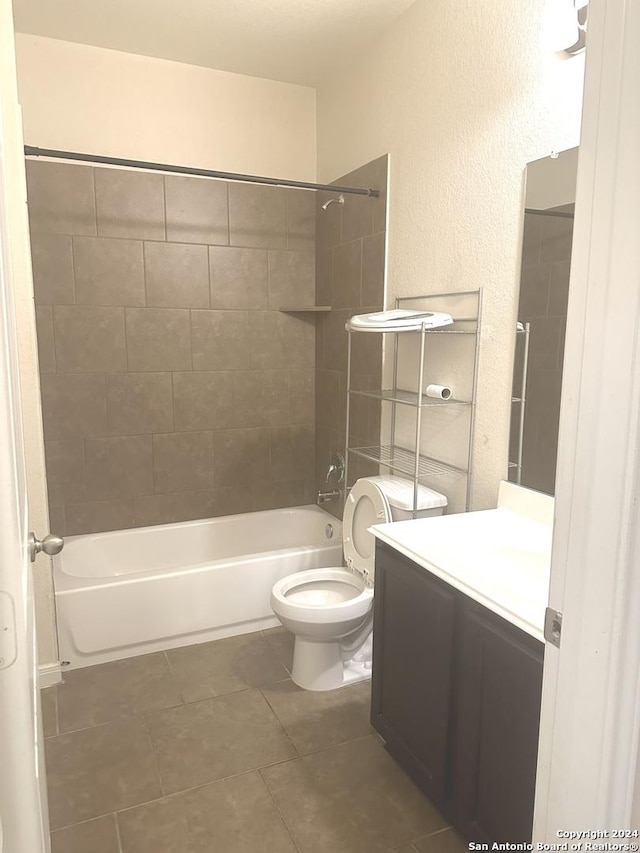 full bathroom featuring tile patterned flooring, vanity, toilet, and tiled shower / bath