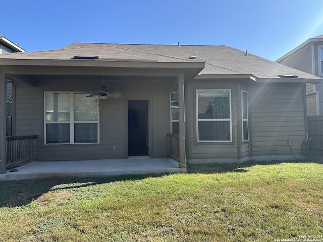 rear view of property with ceiling fan, a yard, and a patio