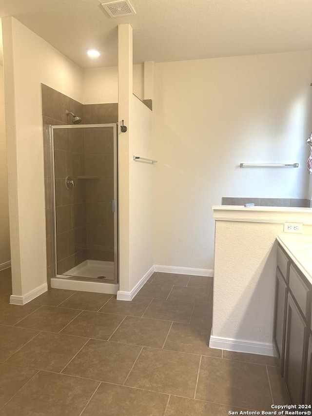 bathroom featuring tile patterned flooring, vanity, and a shower with door