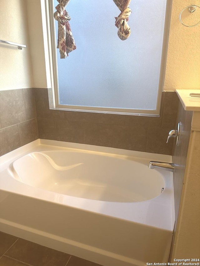 bathroom featuring tile patterned flooring and a tub to relax in