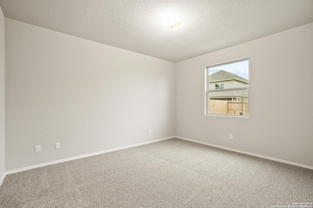 carpeted empty room with a textured ceiling