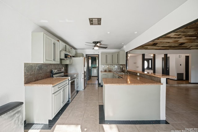 kitchen featuring sink, ceiling fan, appliances with stainless steel finishes, tasteful backsplash, and kitchen peninsula