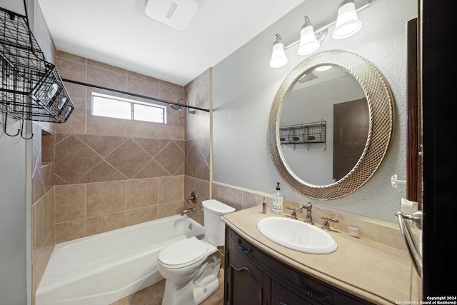 full bathroom featuring vanity, tiled shower / bath combo, and toilet