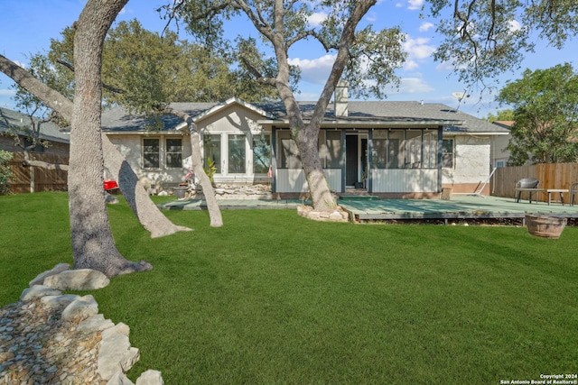 back of house with a wooden deck, a sunroom, and a yard