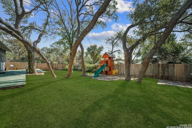 view of yard featuring a playground and a deck