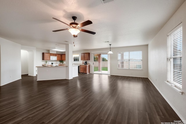 unfurnished living room featuring ceiling fan, dark wood-type flooring, and a textured ceiling