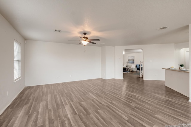 unfurnished living room with wood-type flooring, a textured ceiling, and ceiling fan