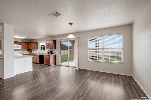 kitchen featuring pendant lighting, white appliances, a textured ceiling, and dark hardwood / wood-style flooring