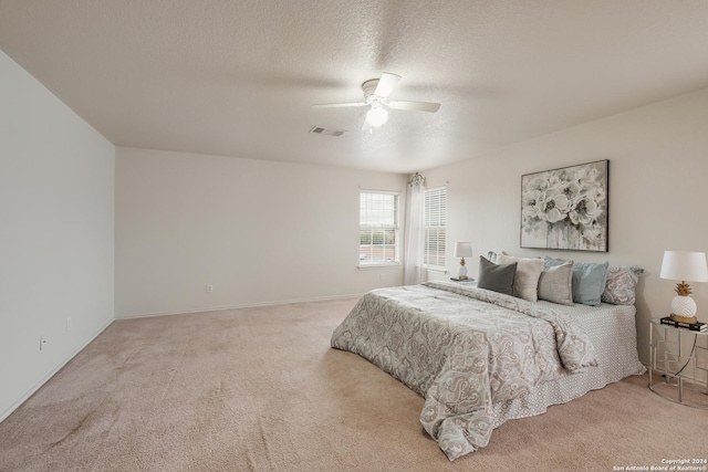 bedroom with carpet, a textured ceiling, and ceiling fan