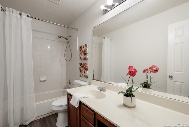 full bathroom with shower / bath combo, a textured ceiling, toilet, vanity, and hardwood / wood-style flooring