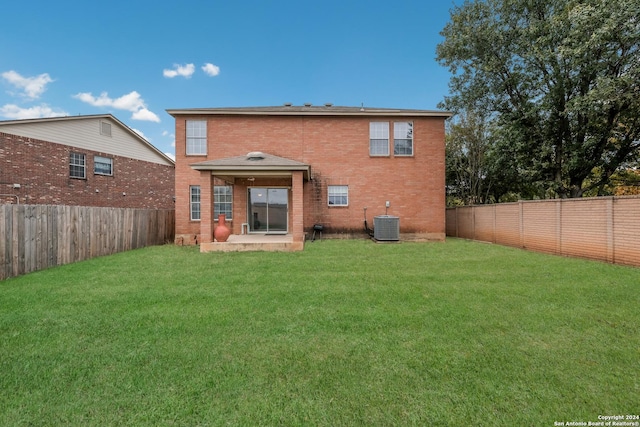 rear view of property featuring a yard, central AC, and a patio area