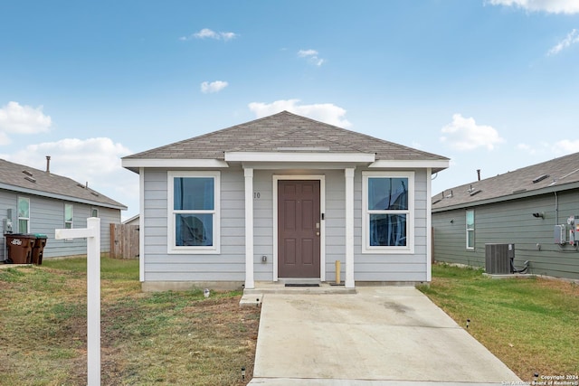 bungalow with central AC unit and a front lawn